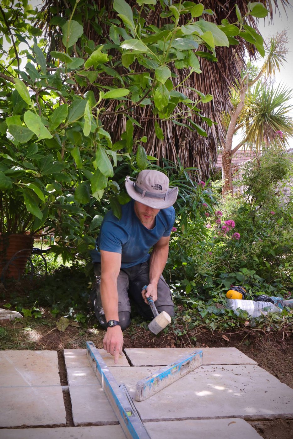 Landscaper levelling paving slabs in a garden